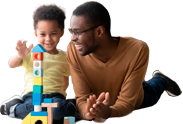 Father and son smiling while playing with blocks